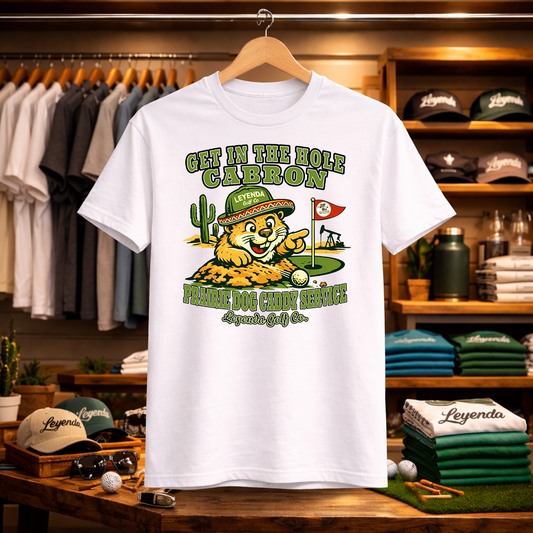 White t-shirt with a colorful graphic design on a wooden table in a store setting.